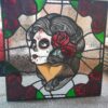 Vibrantly colored stained glass artwork depicting 'La Muerte,' showcasing intricate details and profound symbolism.