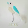 Glass bird with thin wire legs. Blue glass set in as a wing, opaque white for the chest and lower body, and white tail. Blu's head is cut from a very light, translucent pink glass. His blue, transparent beak gives balance to his whole set of features.