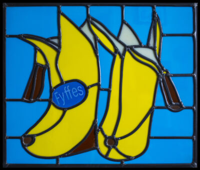 Stunning stained glass rendition of iconic banana boots, a tribute to comedian Billy Connolly's footwear, blending pop art and traditional craftsmanship.