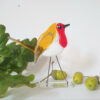 Glass bird named Red. Made from Red, amber and white fused glass. Straight wire legs fused to a clear glass base.